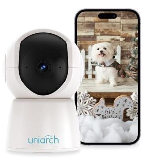 camara inteligente color blanco que detecta movimiento y se comunica con otros dispositivos con un celular detrás que muestra un perro